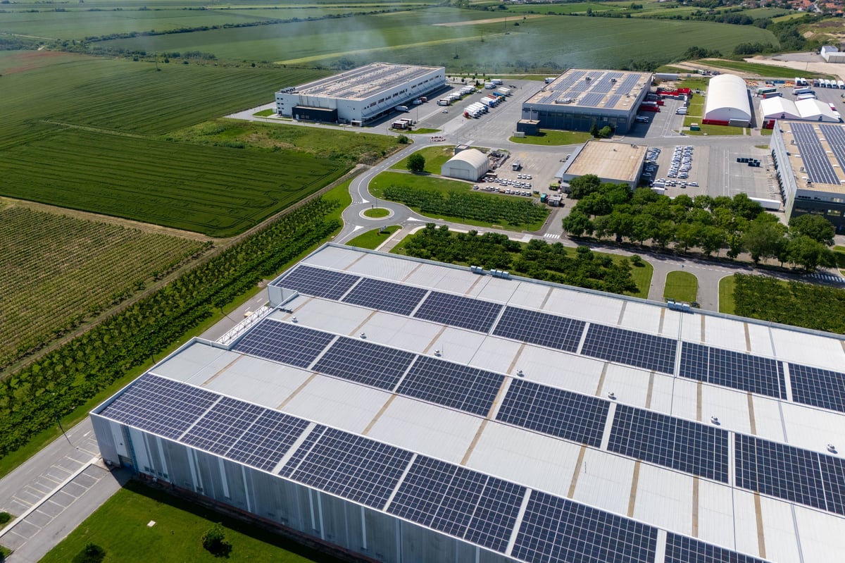 Aerial view of a modern logistics center with solar panels on the roof